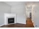 Bright living room with a fireplace, hardwood floors, and a hallway leading to a kitchen with stainless steel appliances at 1579 Eastern Sunrise Ln, Decatur, GA 30034