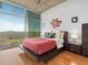 Modern bedroom features a low platform bed with a red quilt, city views, and light hardwood floors at 250 Pharr Ne Rd # 1812, Atlanta, GA 30305