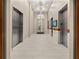 Hallway with stainless steel elevators, decorative lighting and mirrors, bench seating and tile flooring at 250 Pharr Ne Rd # 1812, Atlanta, GA 30305