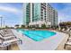 Community outdoor pool and sundeck with multiple lounge chairs and high rise building in the background at 250 Pharr Ne Rd # 1812, Atlanta, GA 30305