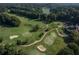 Expansive aerial view showcases the golf course's beautiful layout surrounded by mature trees and a tranquil lake at 7145 Hartsfield Pl, Suwanee, GA 30024