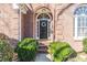 Close-up of a charming front door, brick entrance, and well-maintained landscaping at 7145 Hartsfield Pl, Suwanee, GA 30024