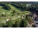 Enjoy this aerial view of the well-manicured golf course, including sand traps, greens, and a charming clubhouse at 7145 Hartsfield Pl, Suwanee, GA 30024