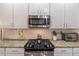 Close up of kitchen featuring stainless steel appliances, granite countertops, and a tile backsplash at 7145 Hartsfield Pl, Suwanee, GA 30024