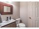 Stylish powder room featuring modern fixtures, a wood framed mirror and neutral tones at 7145 Hartsfield Pl, Suwanee, GA 30024