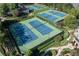 Aerial view of multiple tennis courts surrounded by lush landscaping, offering a premier racquet sport experience at 7145 Hartsfield Pl, Suwanee, GA 30024