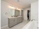 Bright bathroom featuring double sinks, soaking tub, and marble tile at 456 Millsap Way, Marietta, GA 30060