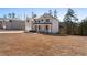 Two-story home with a brick facade, covered porch, attached garage, and a large front yard with trees in the background at 514 Eagles Pt, Fairburn, GA 30213