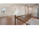 Bright hallway featuring hardwood floors, two windows, a ceiling fan, and classic railing at 514 Eagles Pt, Fairburn, GA 30213