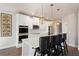 Modern kitchen with white cabinets, island seating, and stylish pendant lighting at 514 Eagles Pt, Fairburn, GA 30213