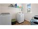 Laundry room with washer, dryer, window, and storage shelving at 514 Eagles Pt, Fairburn, GA 30213