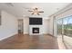 Open-concept living room with fireplace, mounted TV, and a sliding door to the deck at 514 Eagles Pt, Fairburn, GA 30213