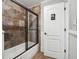 Bathroom featuring a tiled shower with glass doors and restroom signage on the door at 789 Pathview Ct, Dacula, GA 30019