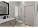 Well-lit bathroom with a sink, toilet, framed mirror and a tiled floor at 1052 Donnelly Sw Ave, Atlanta, GA 30310