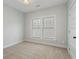 Cozy bedroom with neutral carpeting, a large window, and a white door at 1052 Donnelly Sw Ave, Atlanta, GA 30310