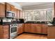 Well-lit kitchen featuring stainless steel appliances, granite countertops, and warm wood cabinetry at 1716 N Springs Dr, Atlanta, GA 30338