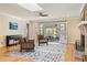 Bright living room with a brick fireplace, skylight, hardwood floors, and views to the outdoor screened porch at 1716 N Springs Dr, Atlanta, GA 30338