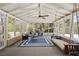 Enclosed sunroom featuring outdoor furniture, a ceiling fan, and a porch swing at 1716 N Springs Dr, Atlanta, GA 30338