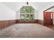 Bright living room with vaulted ceilings, large windows, wood paneling, and carpet at 3252 Westbrook Trce, Lawrenceville, GA 30044
