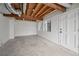 Spacious basement with concrete floor, exposed wooden beams, and natural light from exterior windows at 5780 Bearing Way, Atlanta, GA 30349