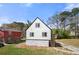 Charming two-story home featuring a deck and stone accents on the lower level, surrounded by lush greenery at 5780 Bearing Way, Atlanta, GA 30349