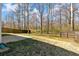 Expansive backyard features wood fence, well-maintained grass, mature trees, and a concrete slab, and borders the woods at 81 Summer Creek Dr, Dallas, GA 30157