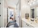 Hall bathroom features a black tile floor, white vanity, and framed inspirational quote at 2883 Misty Rock Cv, Dacula, GA 30019