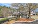 Community clubhouse featuring a covered porch, manicured landscaping, and convenient parking at 2883 Misty Rock Cv, Dacula, GA 30019