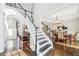 Bright foyer showcasing a staircase with wooden steps and white railings, complemented by hardwood floors and neutral decor at 2883 Misty Rock Cv, Dacula, GA 30019