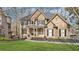Beautiful two-story home featuring a manicured lawn, stone accents, and covered front porch with the American flag at 2883 Misty Rock Cv, Dacula, GA 30019
