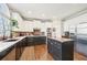 Modern kitchen with white upper cabinets, black lower cabinets, an island, stainless steel appliances, and brick backsplash at 2883 Misty Rock Cv, Dacula, GA 30019
