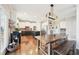 Spacious kitchen with wooden dining table, white upper cabinets, black lower cabinets, an island, and stainless steel appliances at 2883 Misty Rock Cv, Dacula, GA 30019