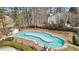 Aerial view of a community lazy river with mature trees, playground, and clubhouse at 2883 Misty Rock Cv, Dacula, GA 30019