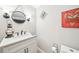 Stylish powder room featuring a modern vanity with quartz countertop, decorative mirror, and wall sconces at 2883 Misty Rock Cv, Dacula, GA 30019