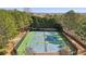 Aerial view of the community tennis courts surrounded by mature trees, providing a private setting at 2883 Misty Rock Cv, Dacula, GA 30019