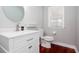 Charming powder room with white vanity, modern faucet, round mirror and stylish decor at 5529 Camden Lake Pointe Nw, Acworth, GA 30101