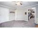 Spacious carpeted bedroom featuring a ceiling fan, neutral paint, and a doorway to a walk-in closet for easy storage at 5529 Camden Lake Pointe Nw, Acworth, GA 30101