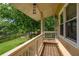 Charming, covered porch with wood flooring and white railing overlooks the green lawn and lake view at 5529 Camden Lake Pointe Nw, Acworth, GA 30101