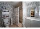 Stylish bathroom with marble wallpaper, featuring shower, vanity, and toilet, creating a luxurious retreat at 7130 Oakley Ct, Union City, GA 30291
