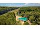 Aerial view of property featuring a home with a green roof, surrounded by trees and a peaceful pond at 9180 Shiloh Dr, Villa Rica, GA 30180