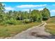 Gravel driveway leading to the home, surrounded by lush trees and greenery at 9180 Shiloh Dr, Villa Rica, GA 30180