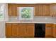 Close up of kitchen with black appliances, wood cabinets, and a view of the yard at 9180 Shiloh Dr, Villa Rica, GA 30180