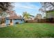 Spacious backyard with lush green grass, a blue house and a wooden fence at 1453 Hartford Sw Ave, Atlanta, GA 30310