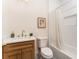 Well-lit bathroom featuring a wood vanity, tub with shower, and tiled accents at 1453 Hartford Sw Ave, Atlanta, GA 30310