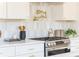 Close-up of kitchen showcasing stainless steel gas range, white cabinets, and stylish tile backsplash at 1453 Hartford Sw Ave, Atlanta, GA 30310