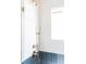 Stylish shower featuring bronze showerhead and controls, glass doors, and modern white and blue tile at 1453 Hartford Sw Ave, Atlanta, GA 30310