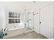 Updated bathroom featuring a glass shower door and a built-in tub near a sunny window at 1039 Ashfern Walk, Woodstock, GA 30189