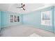 Light blue bedroom with neutral carpet, tray ceilings, and multiple sunny, large windows at 1039 Ashfern Walk, Woodstock, GA 30189