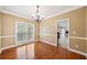 Dining room featuring hardwood floors, a chandelier, large windows, and neutral paint at 1039 Ashfern Walk, Woodstock, GA 30189