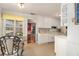 Bright kitchen and breakfast area featuring white cabinetry, a glass-top table and exterior views at 340 Nail Rd, Mcdonough, GA 30253
